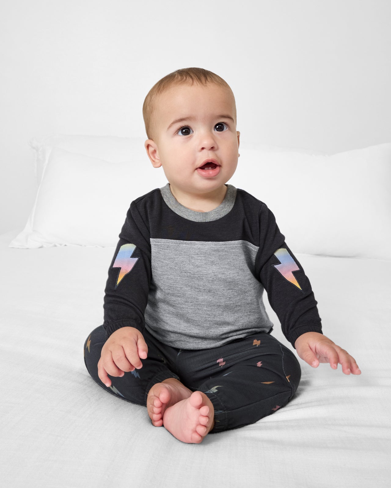 Sitting baby wearing the Rad Bolts Cinched Panel Crewneck
