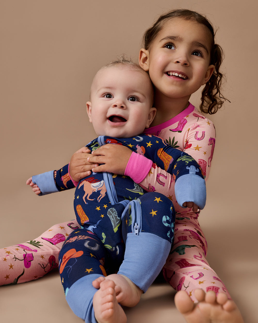 Two children wearing matching Rancher Roundup Pajamas 