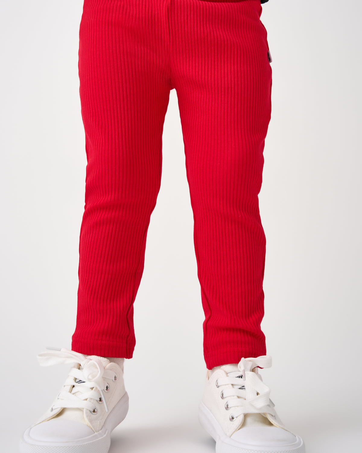 Child wearing the Candy Red Ribbed Legging with white sneakers