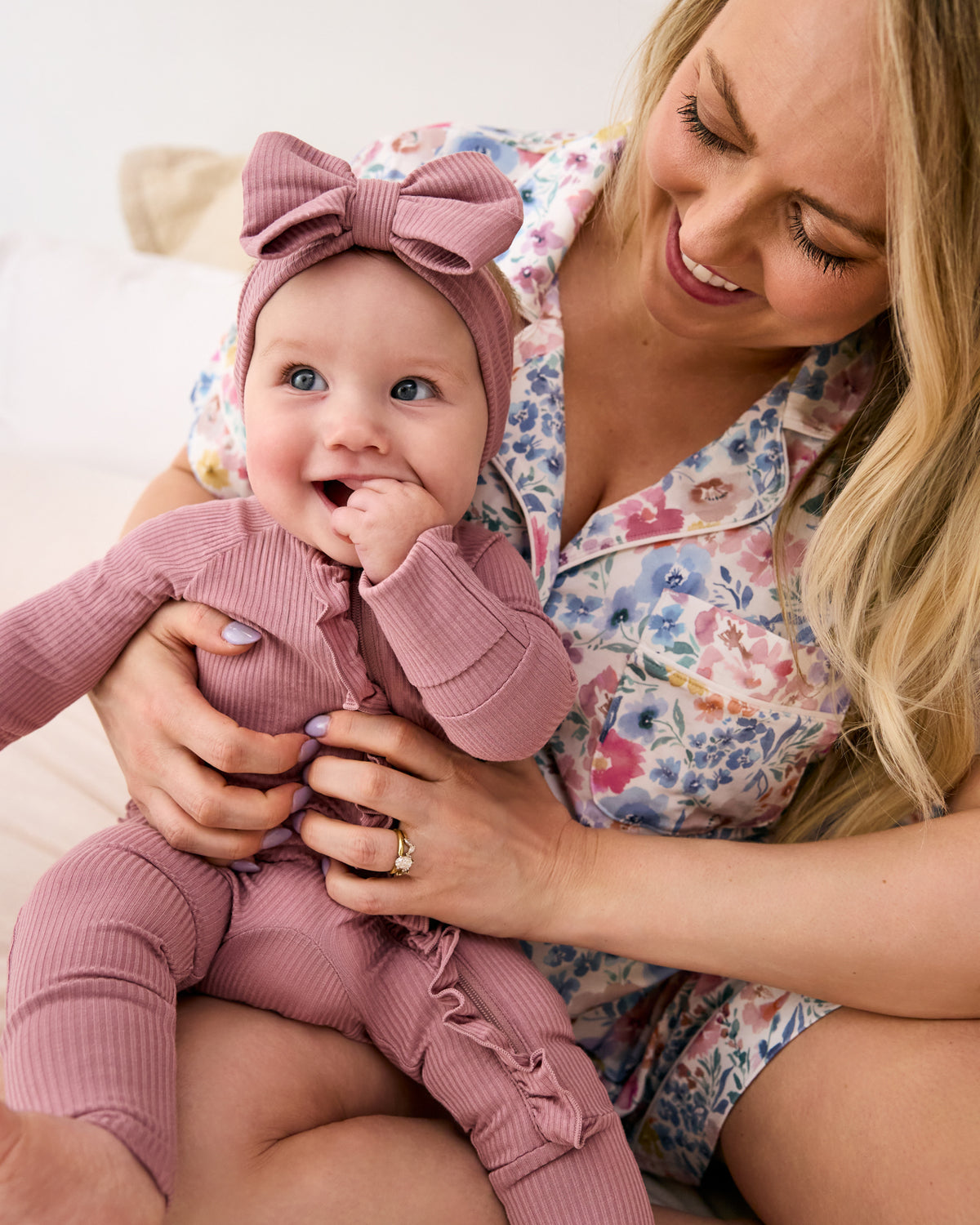 Mother holding newborn wearing the Rosewood Ribbed Ruffle Zippy