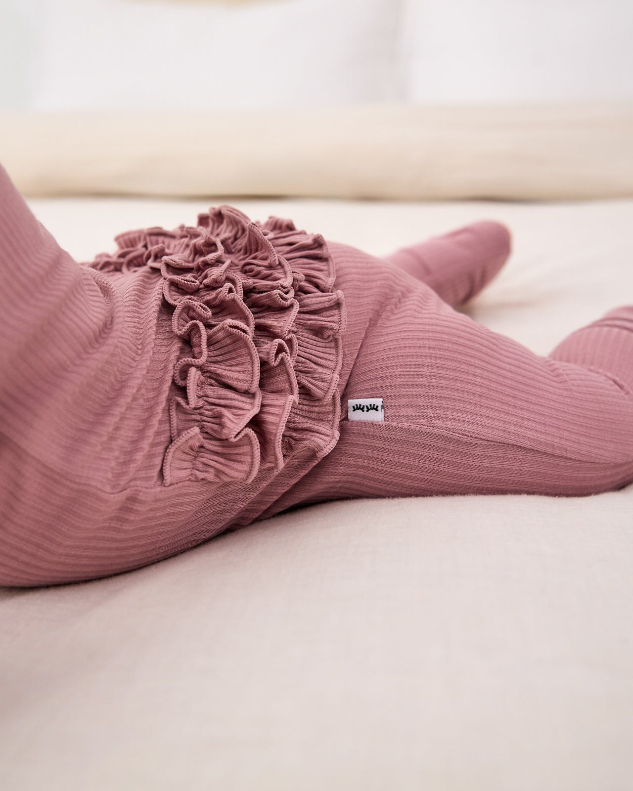 Close up of the ruffle detail on the Rosewood Ribbed Ruffle Zippy