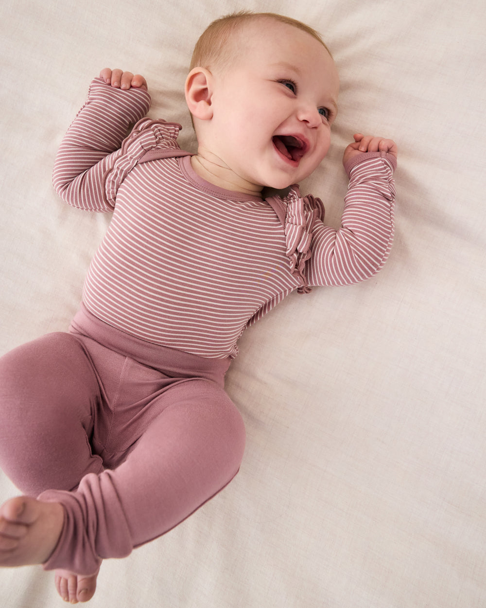 Smiling baby wearing the Rosewood Fold-Over Legging with the Rosewood Striped bodysuit