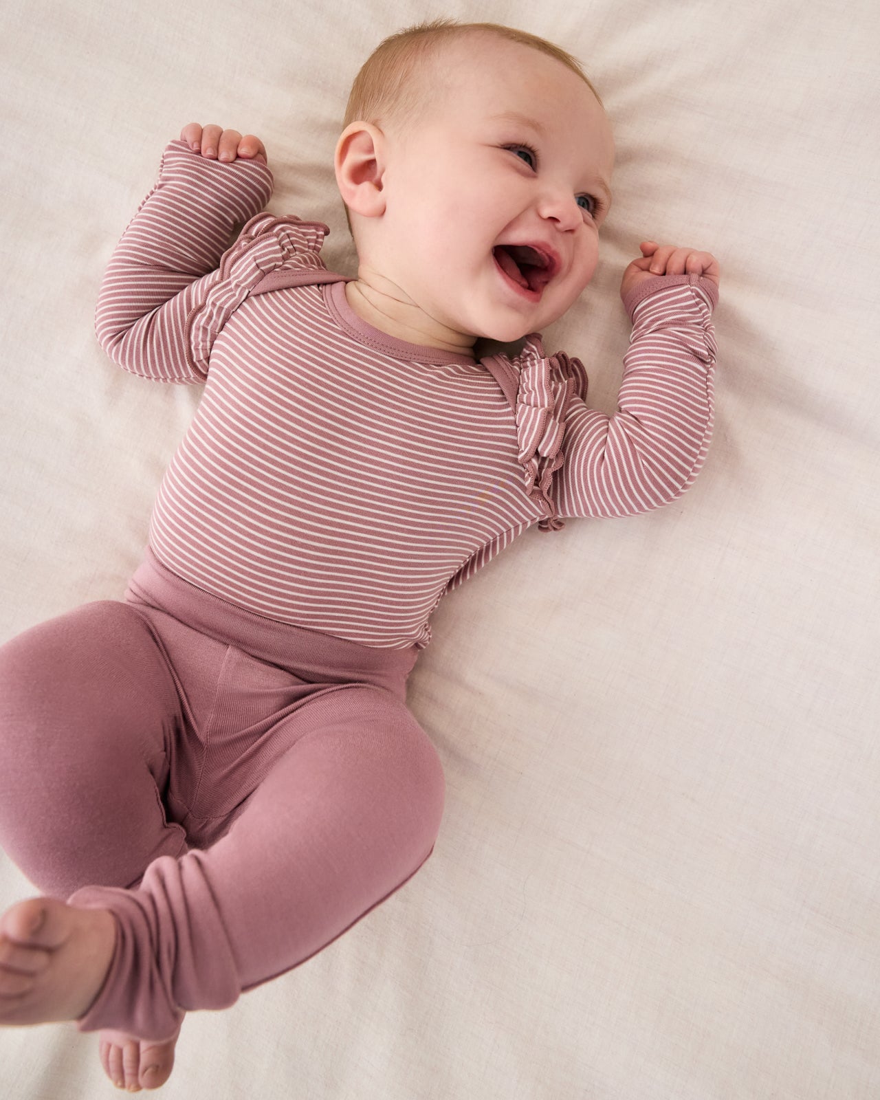 Smiling baby wearing the Rosewood Fold-Over Legging with the Rosewood Striped bodysuit