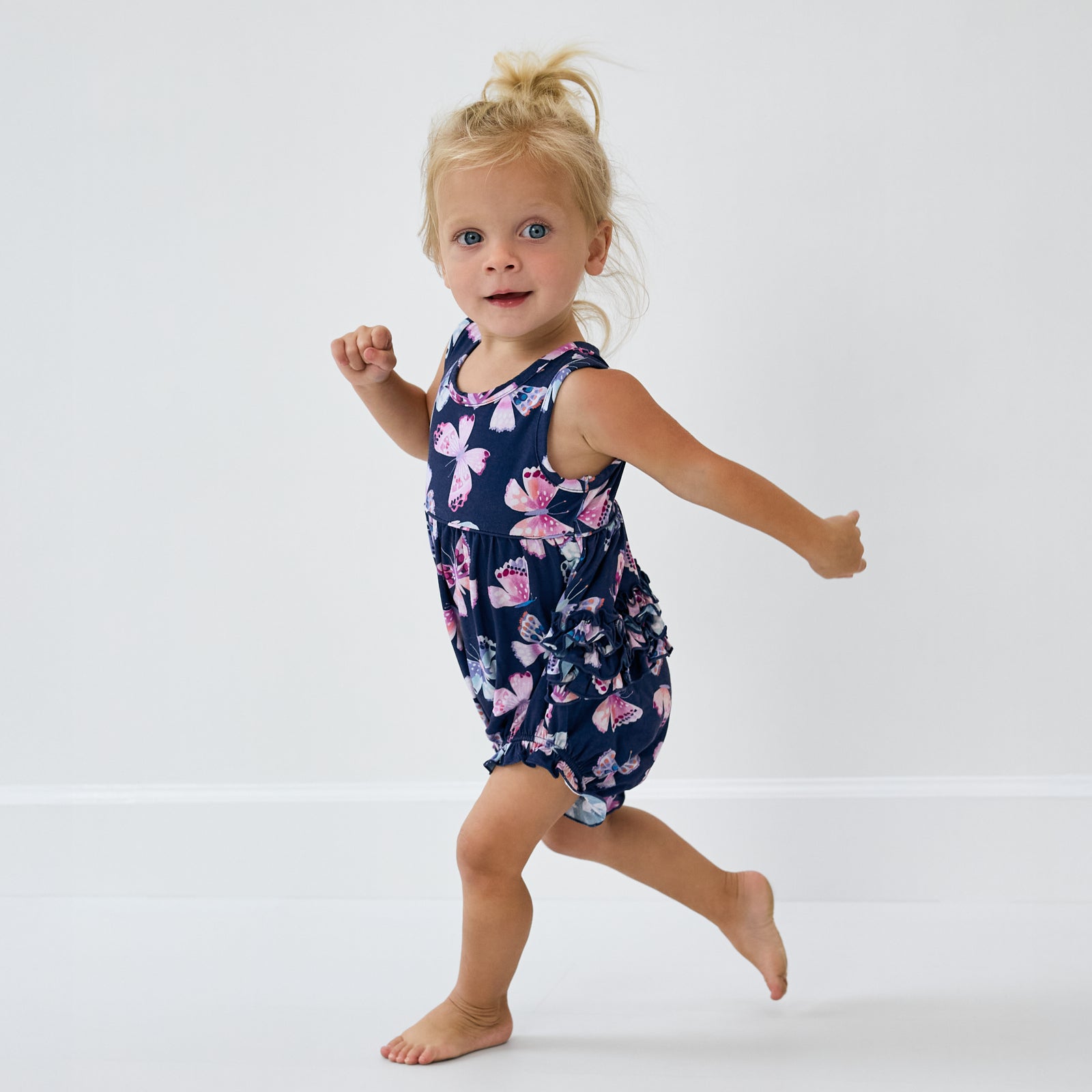Child in motion wearing the Royal Butterflies Bubble Romper