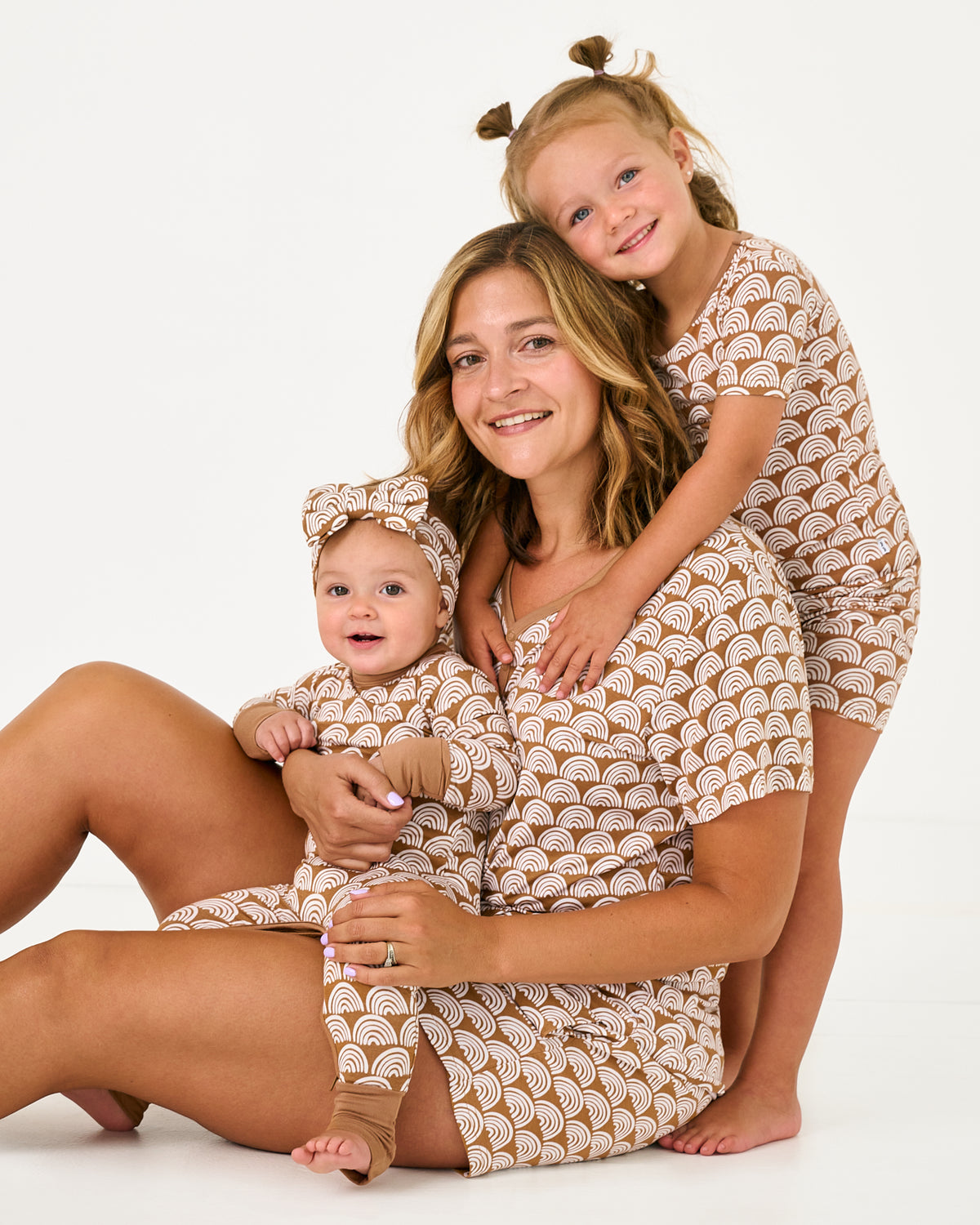 Mother and two children wearing matching Rust Rainbows pajamas
