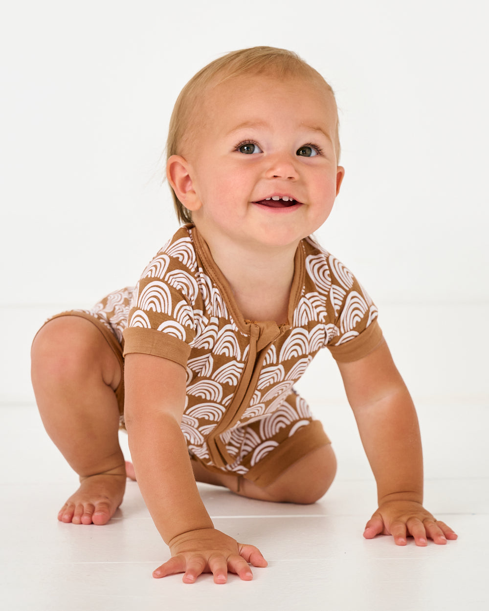 Crawling baby wearing the Rust Rainbows Shorty Zippy