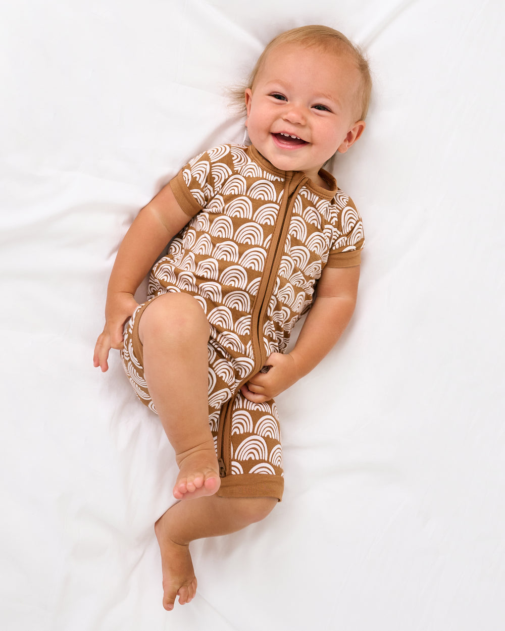 Aerial view of baby wearing the Rust Rainbows Shorty Zippy