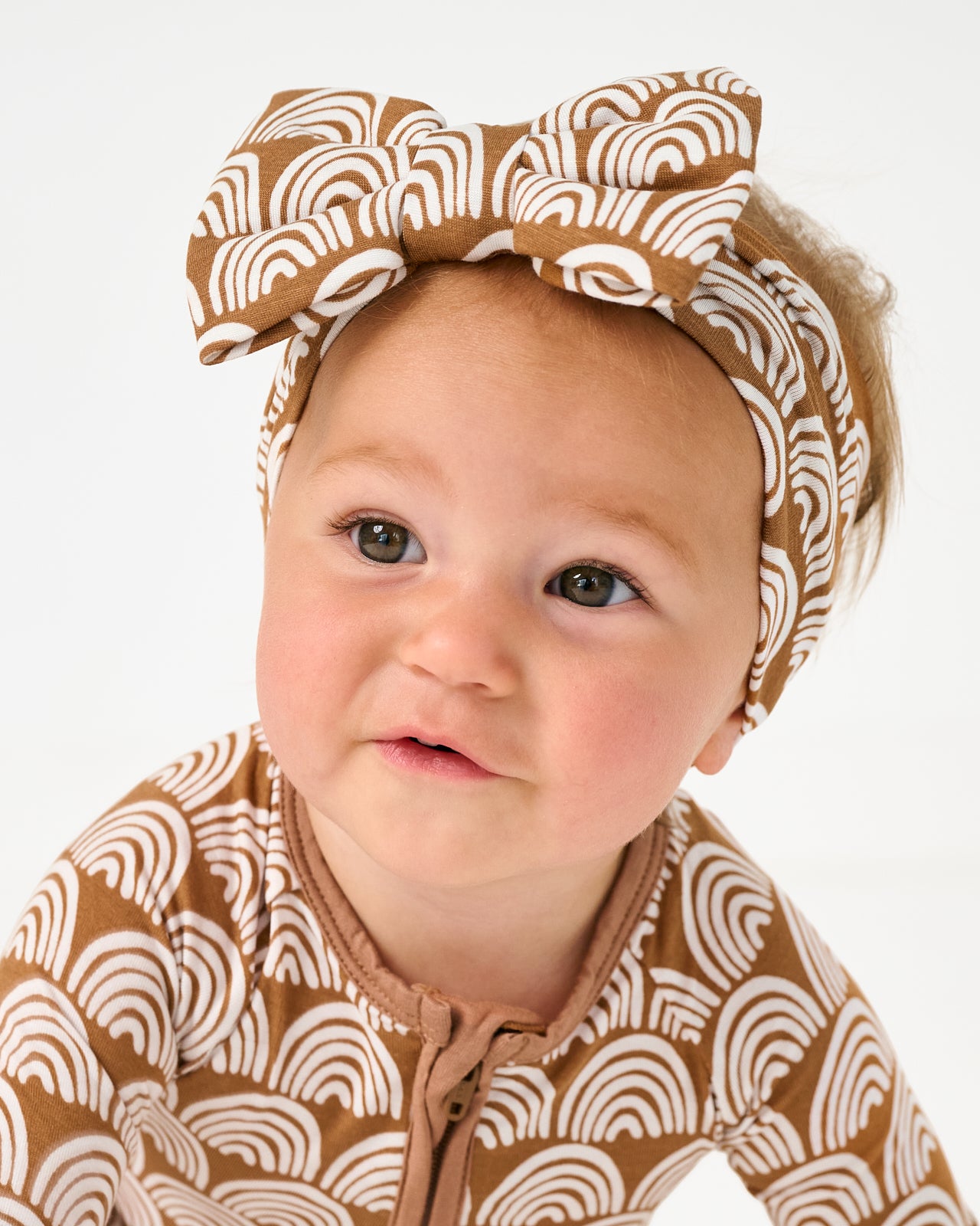 Close up of baby wearing the Rust Rainbows Luxe Bow Headband