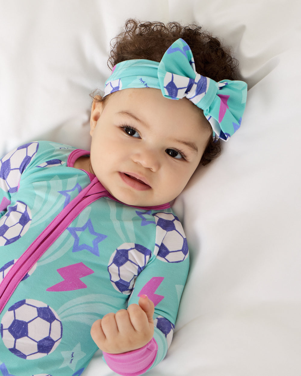Close up of baby wearing the Aqua Soccer Stars Luxe Bow Headband