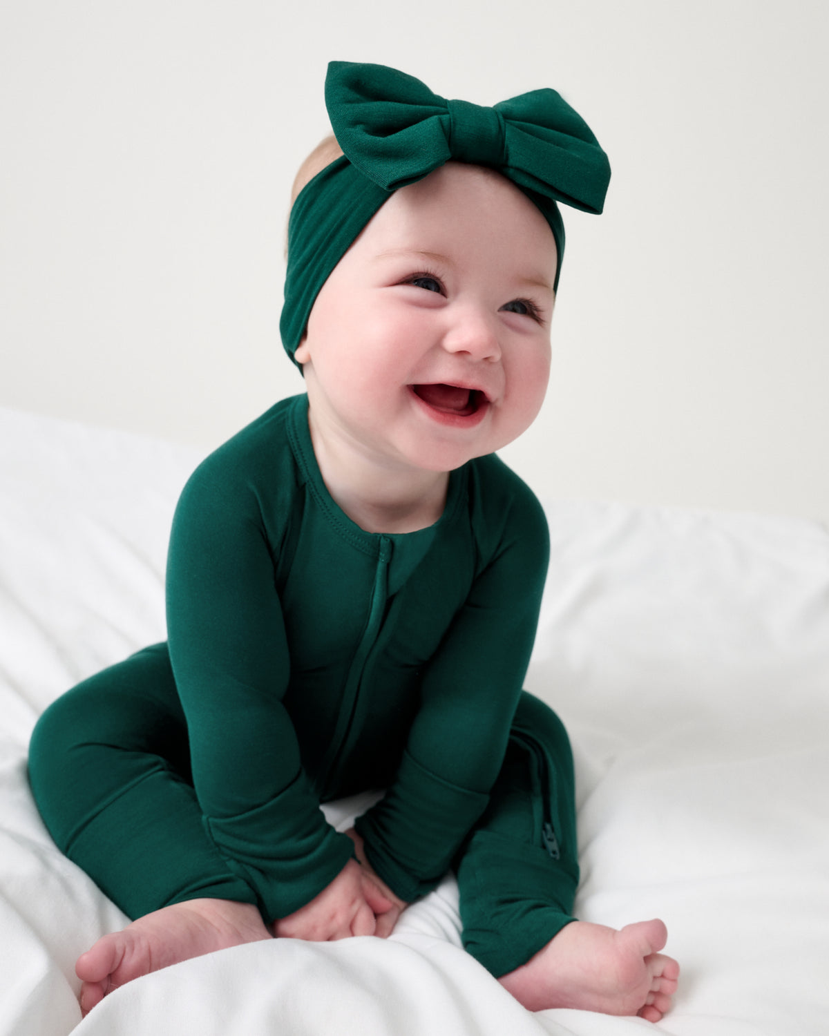 Baby wearing the Emerald Luxe Bow Headband and Zipper Pajama