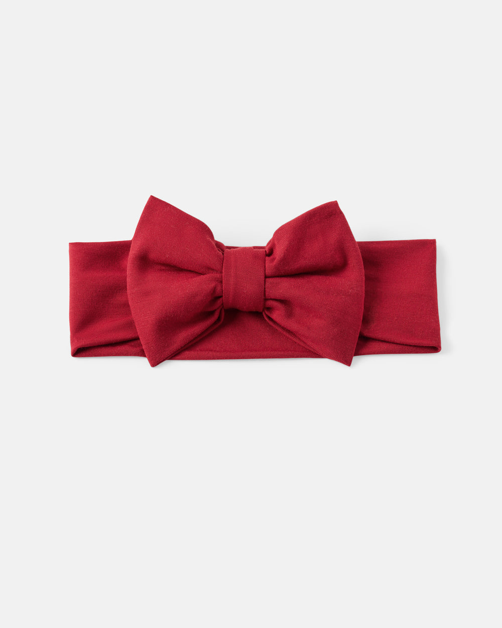 A red fabric headband with a large bow in the center, laid flat against a light gray background.