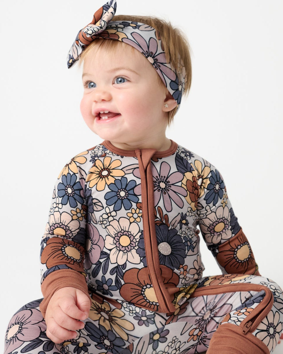 Sitting baby wearing the Wildwood Floral Luxe Bow Headband and Footie