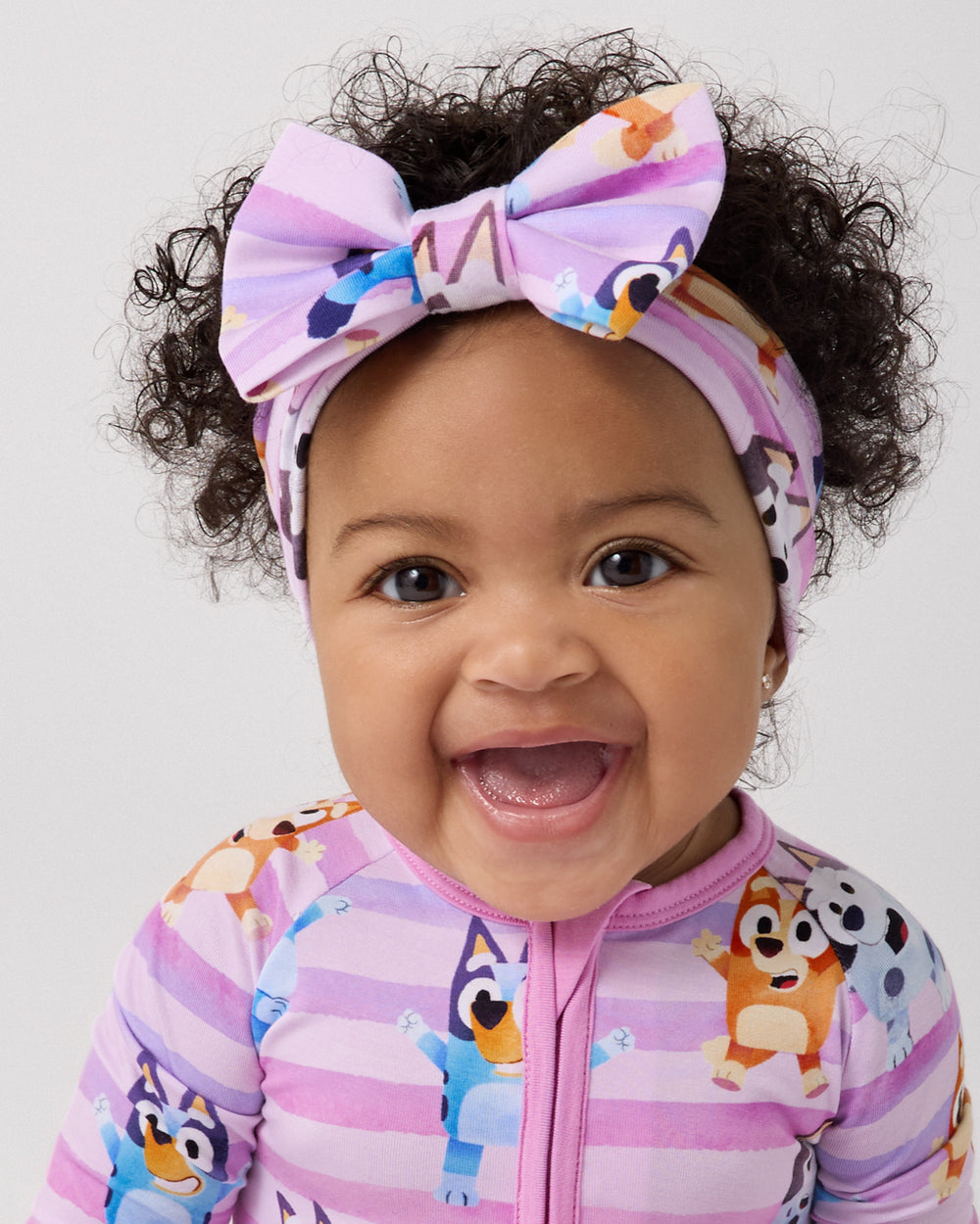 Close up of baby wearing the Pink Bluey Dance All Day Luxe Bow Headband