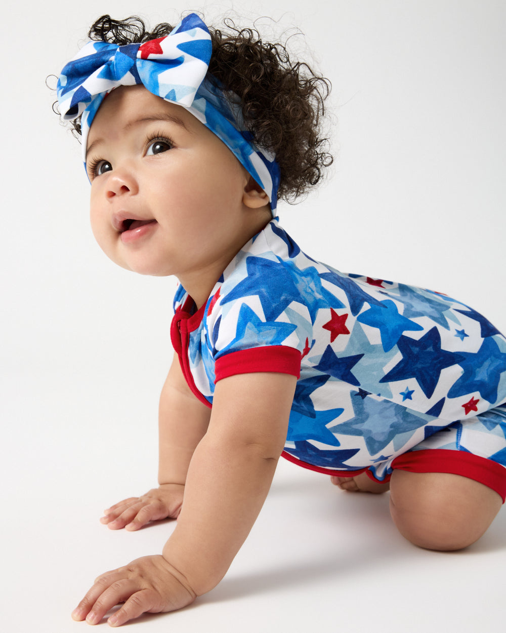 Baby wearing the Starry Splash Luxe Bow Headband and Shorty Zippy