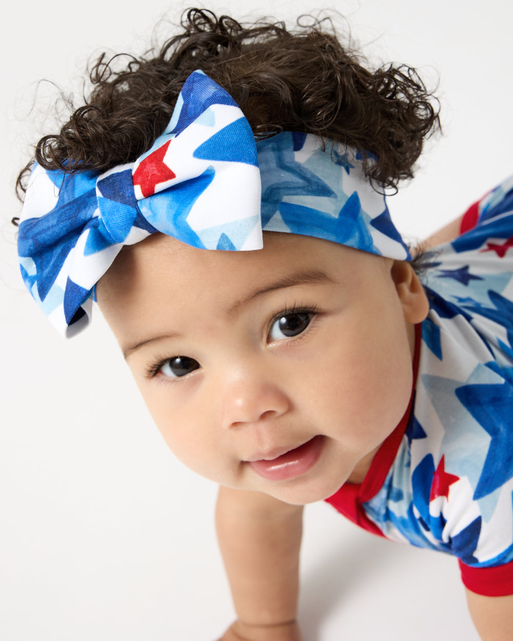Close up of baby wearing the Starry Splash Luxe Bow Headband
