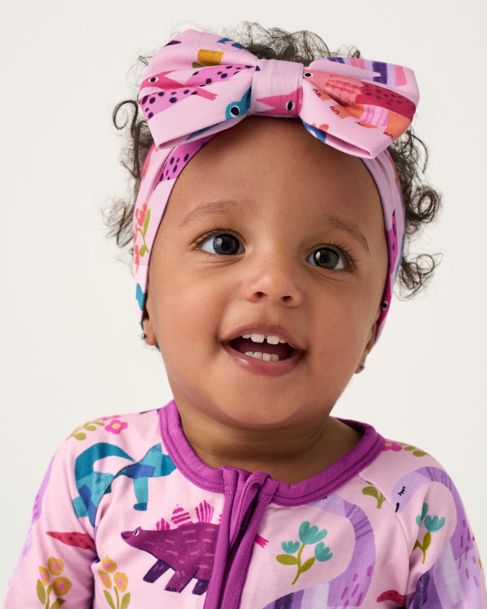 Close up of baby wearing the Pink Roar & Explore Luxe Bow Headband