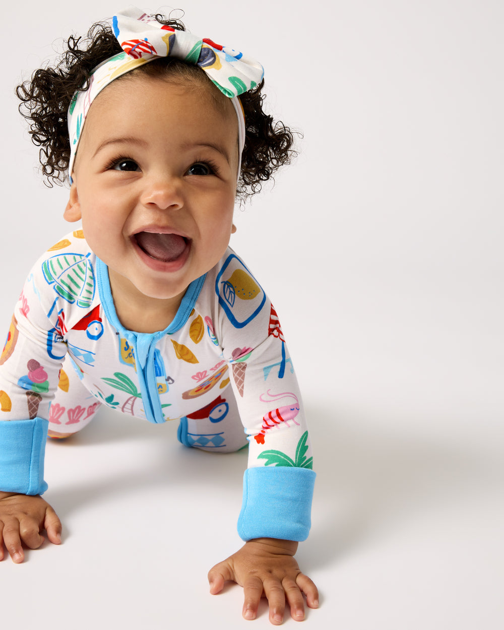 Crawling baby wearing the Ciao Bella Luxe Bow Headband and Zippy