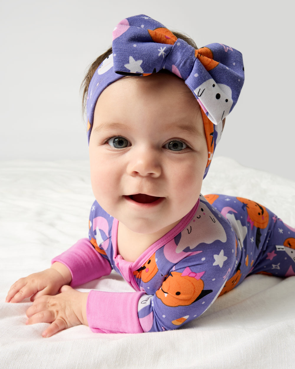 Close up of baby on her tummy wearing the Moonlit Magic Purple Luxe Bow Headband