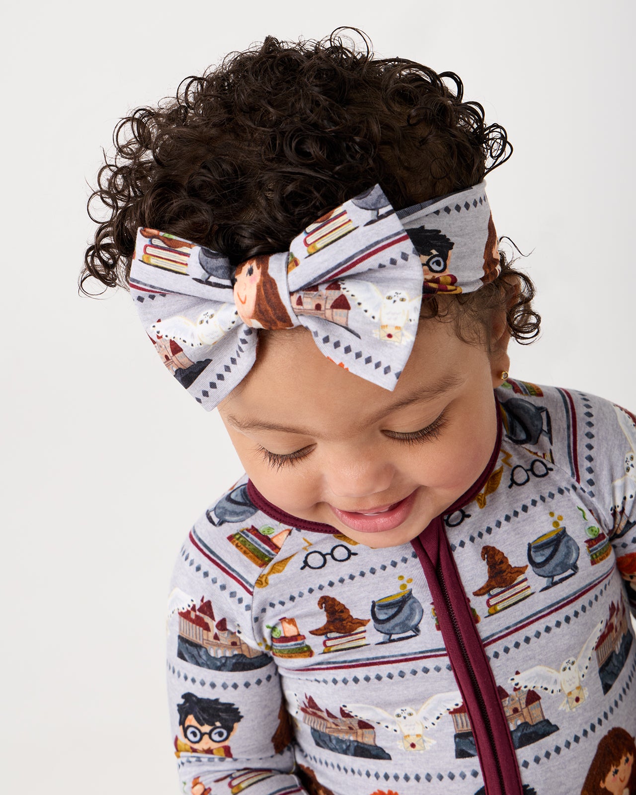 Close up of baby girl wearing the Harry Potter™ Spellbinding Studies Luxe Bow Headband