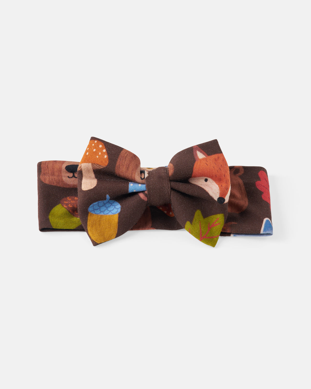 A kids' fabric bow tie and matching headband set featuring a woodland forest print with a fox, mushrooms, acorns, and leaves on a dark brown background, shown against a light gray studio backdrop.