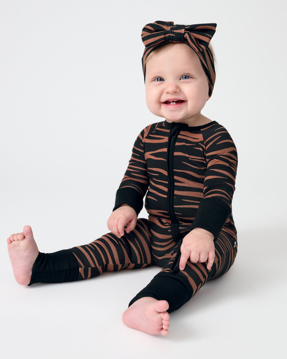 Sitting baby wearing the Wild Stripes Luxe Bow Headband and Zippy