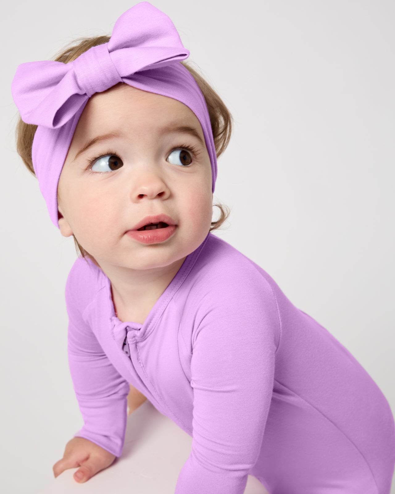 Close up of baby wearing the Soft Wisteria Shorty Zippy