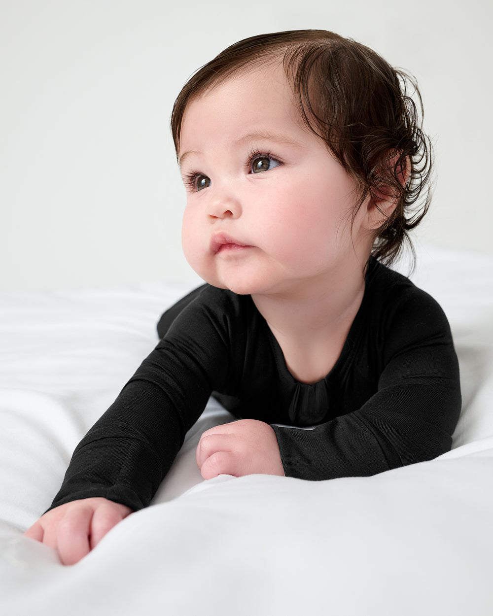 Baby on her tummy wearing the Black Zippy
