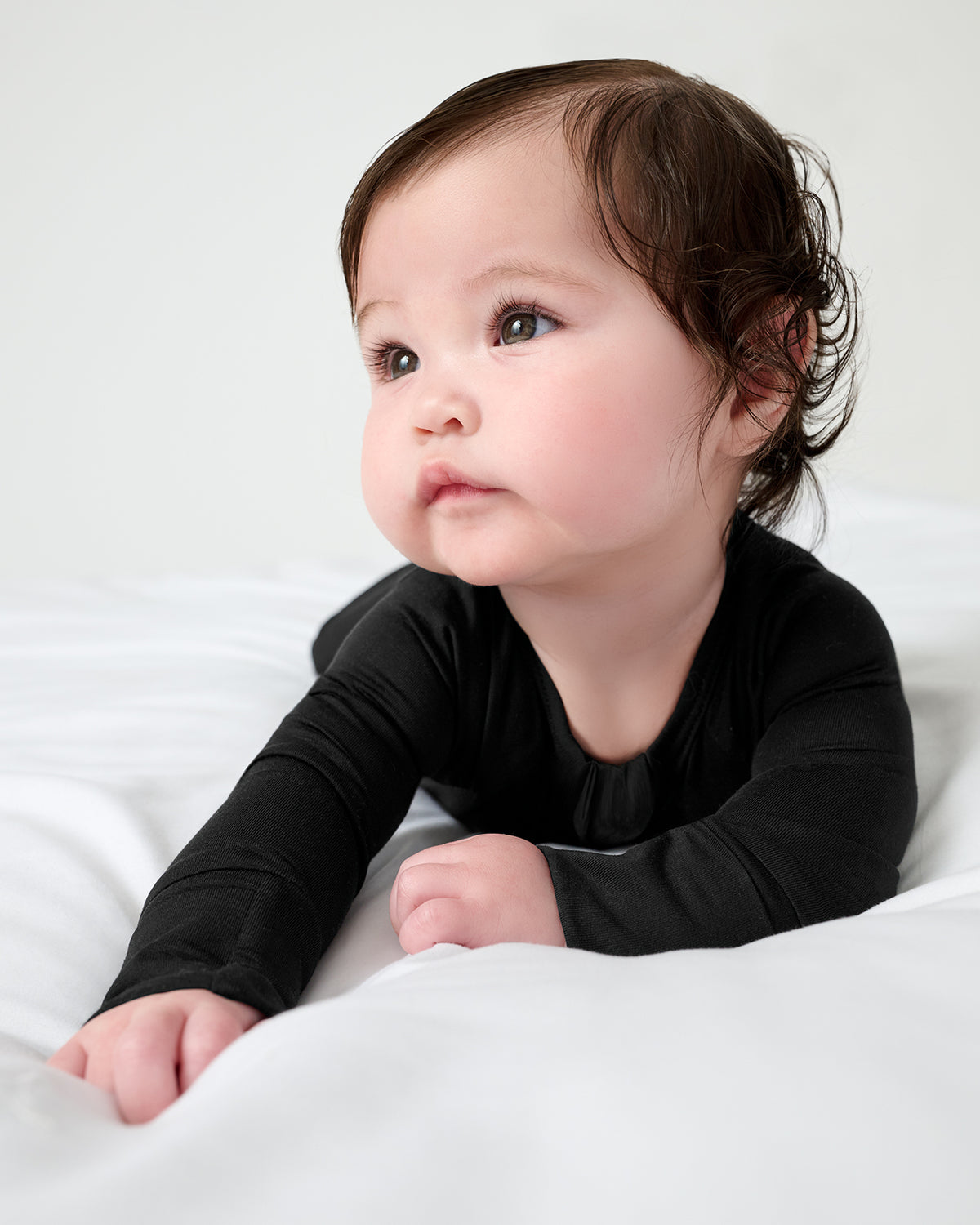 Baby on her tummy wearing the Black Zippy