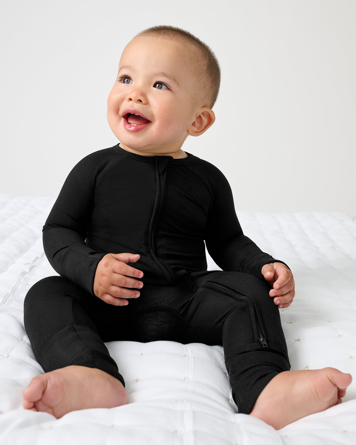 Sitting baby wearing the Black Zippy