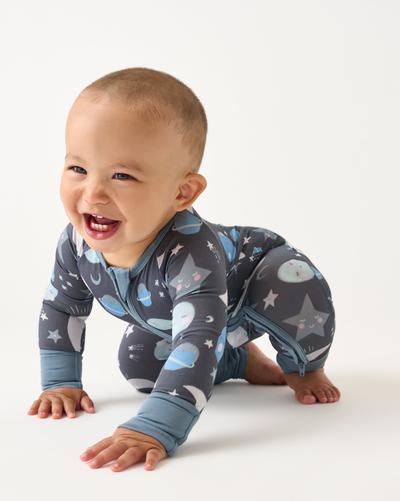 Crawling baby wearing the Blue To the Moon & Back Zippy