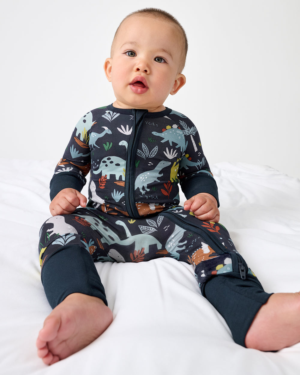 Sitting baby wearing the Navy Jurassic Jungle Zippy