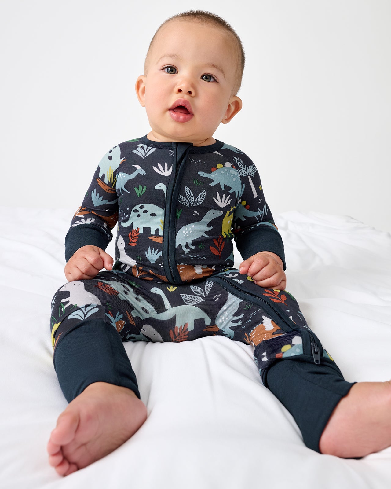 Sitting baby wearing the Navy Jurassic Jungle Zippy