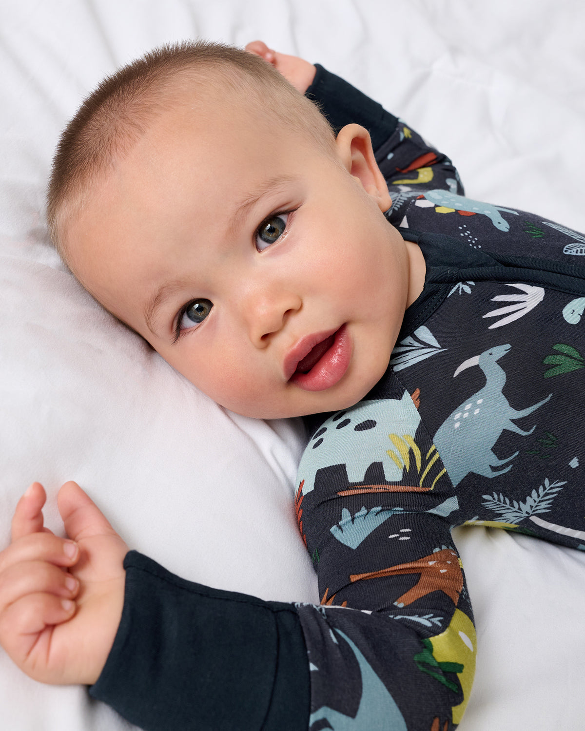 Close up of baby wearing the Navy Jurassic Jungle Zippy