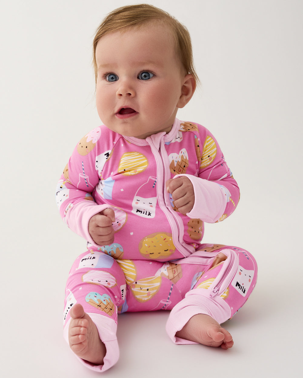 Sitting baby girl wearing the Pink Cookies & Milk Zippy