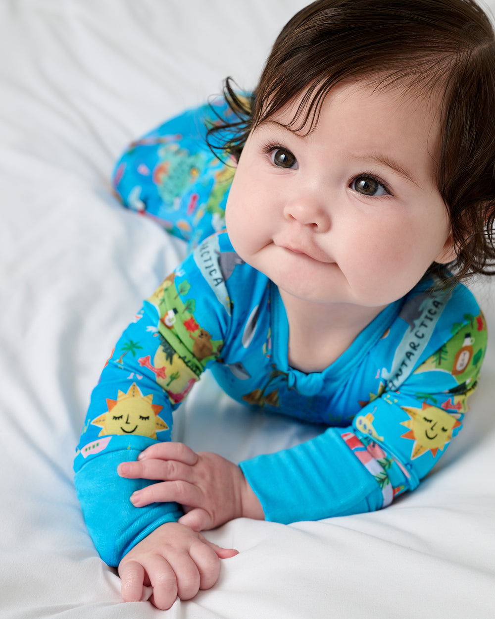 Baby on her tummy wearing the Around The World Zippy