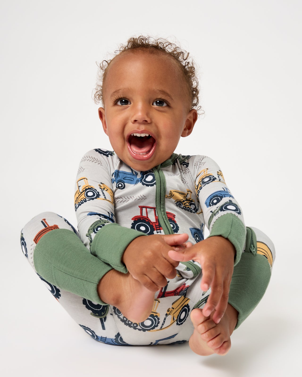 Smiling baby wearing the Tractor Tales Zippy