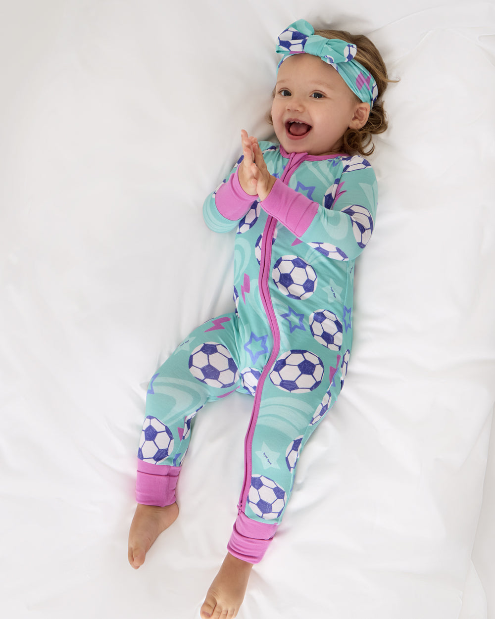 Aerial view of baby wearing the Aqua Soccer Stars Zippy and Luxe Bow Headband