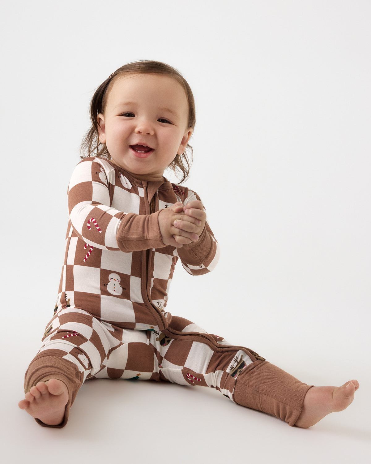 Sitting baby wearing the Holiday Checks Zippy