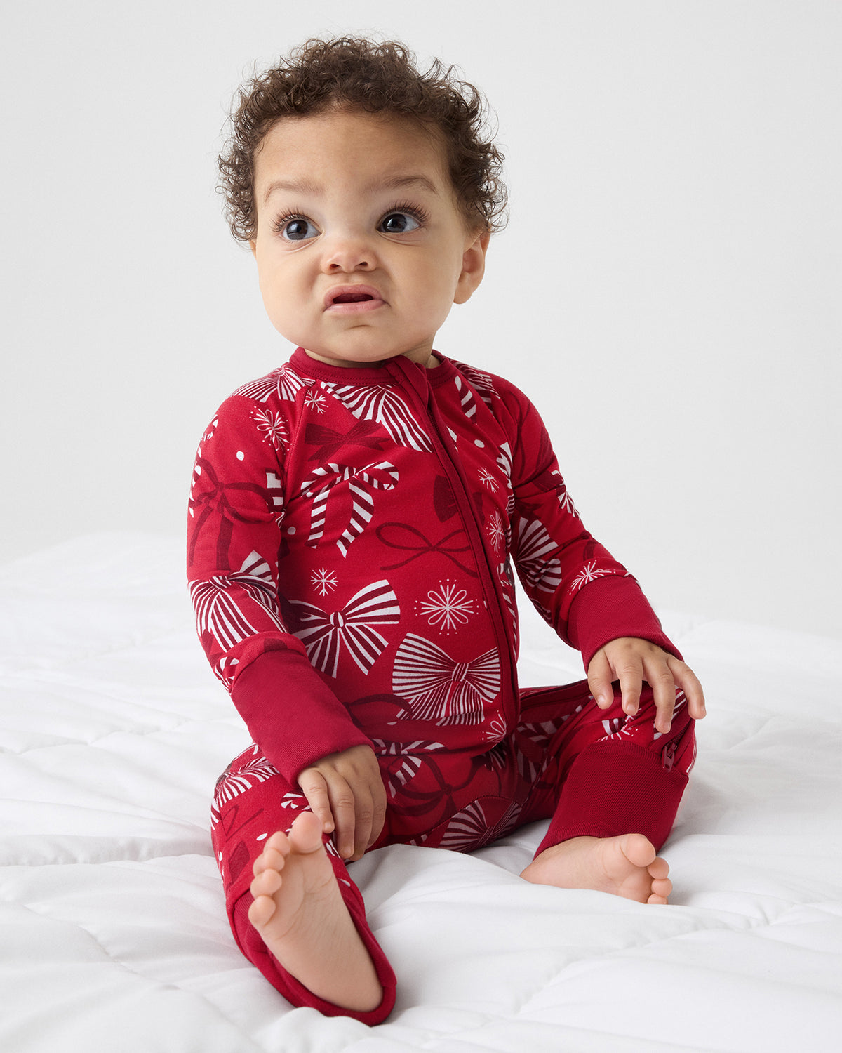 Sitting baby wearing the Holiday Bows Zippy