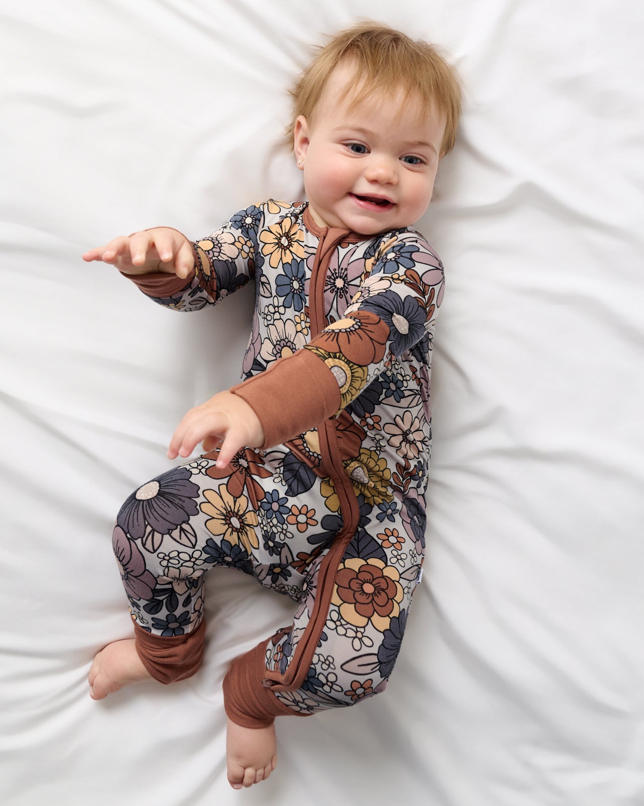 Aerial view of baby wearing the Wildwood Floral Zippy