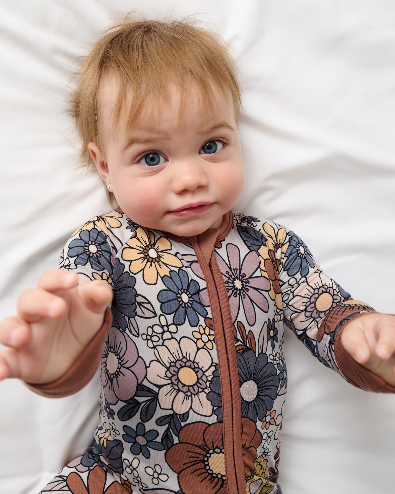 Close up of baby wearing the Wildwood Floral Zippy
