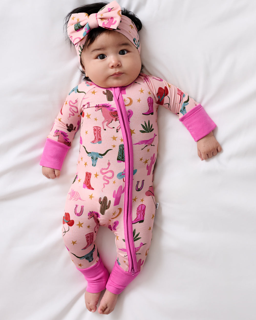 Aerial view of baby wearing the Pink Rancher Roundup Zippy and Luxe Bow Headband