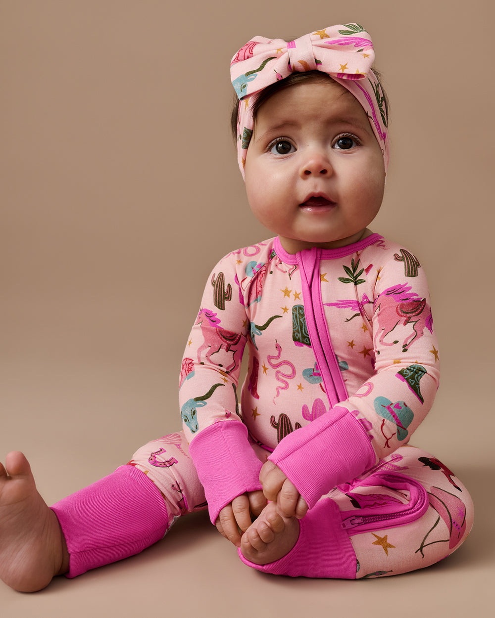Sitting baby wearing the Pink Rancher Roundup Luxe Bow Headband and Zippy