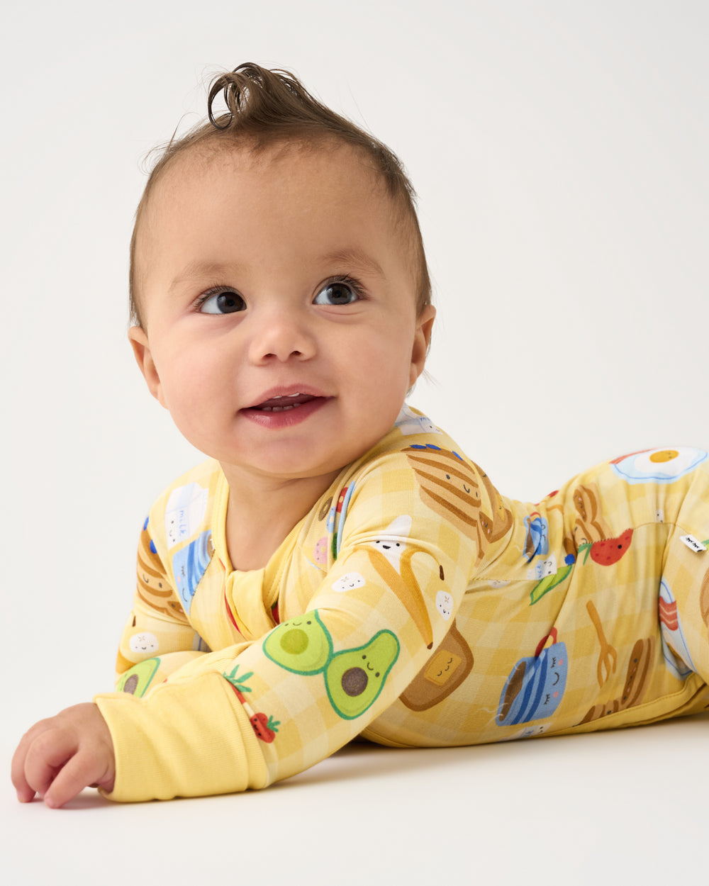 Baby on his tummy wearing the Breakfast Bunch Zippy