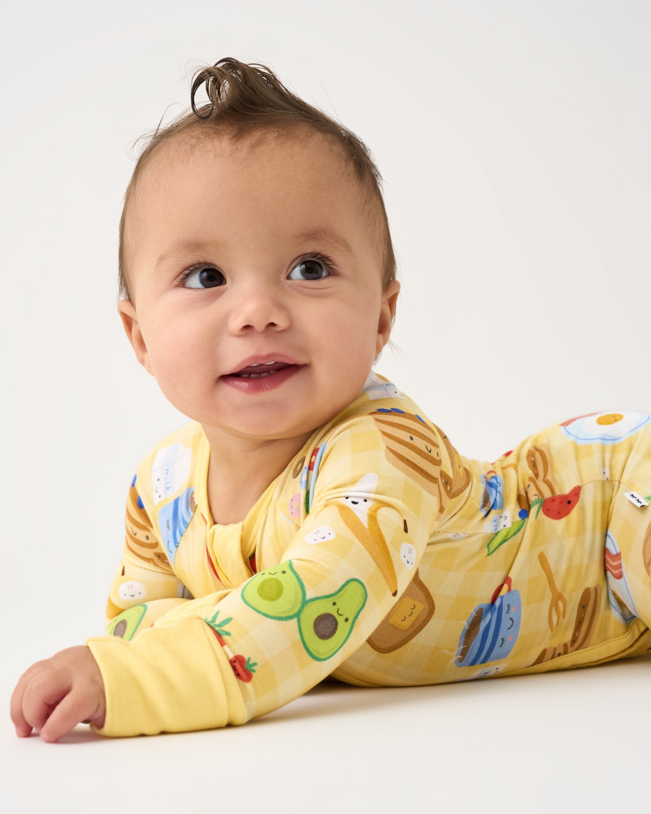 Baby on his tummy wearing the Breakfast Bunch Zippy