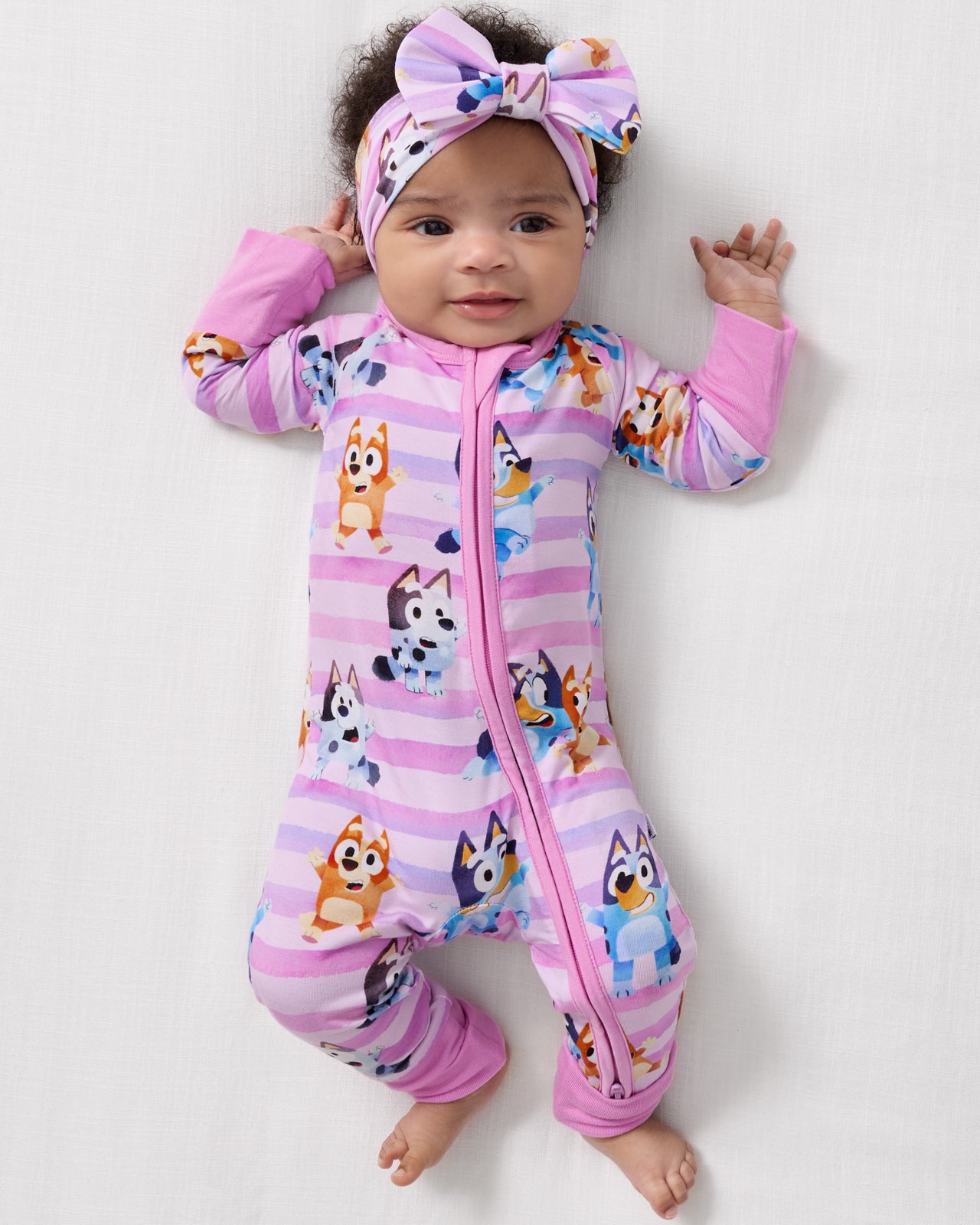 Aerial view of baby wearing the Pink Bluey Dance All Day Zippy and Luxe Bow Headband