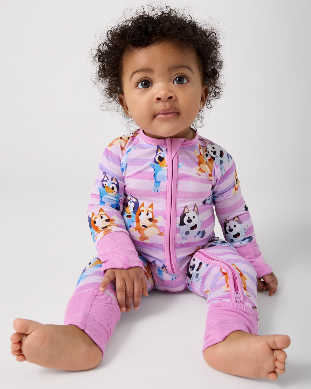 Sitting baby wearing the Pink Bluey Dance All Day Zippy