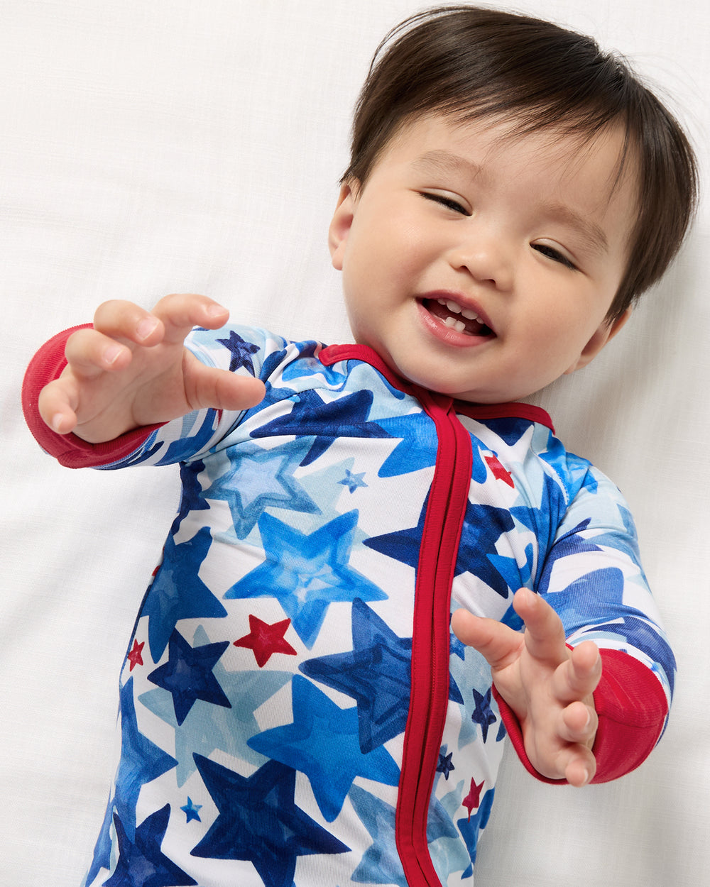 Close up aerial view of baby wearing the Starry Splash Zippy