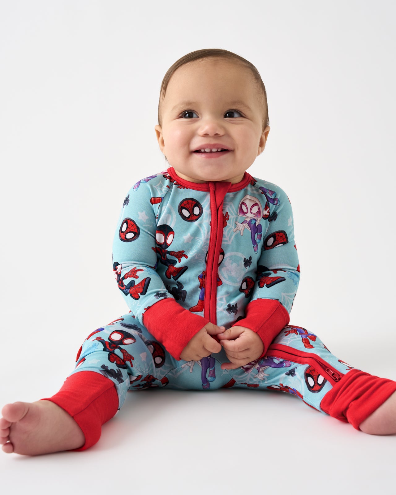 Sitting baby wearing the Spidey & Friends Tiny Webs Zippy