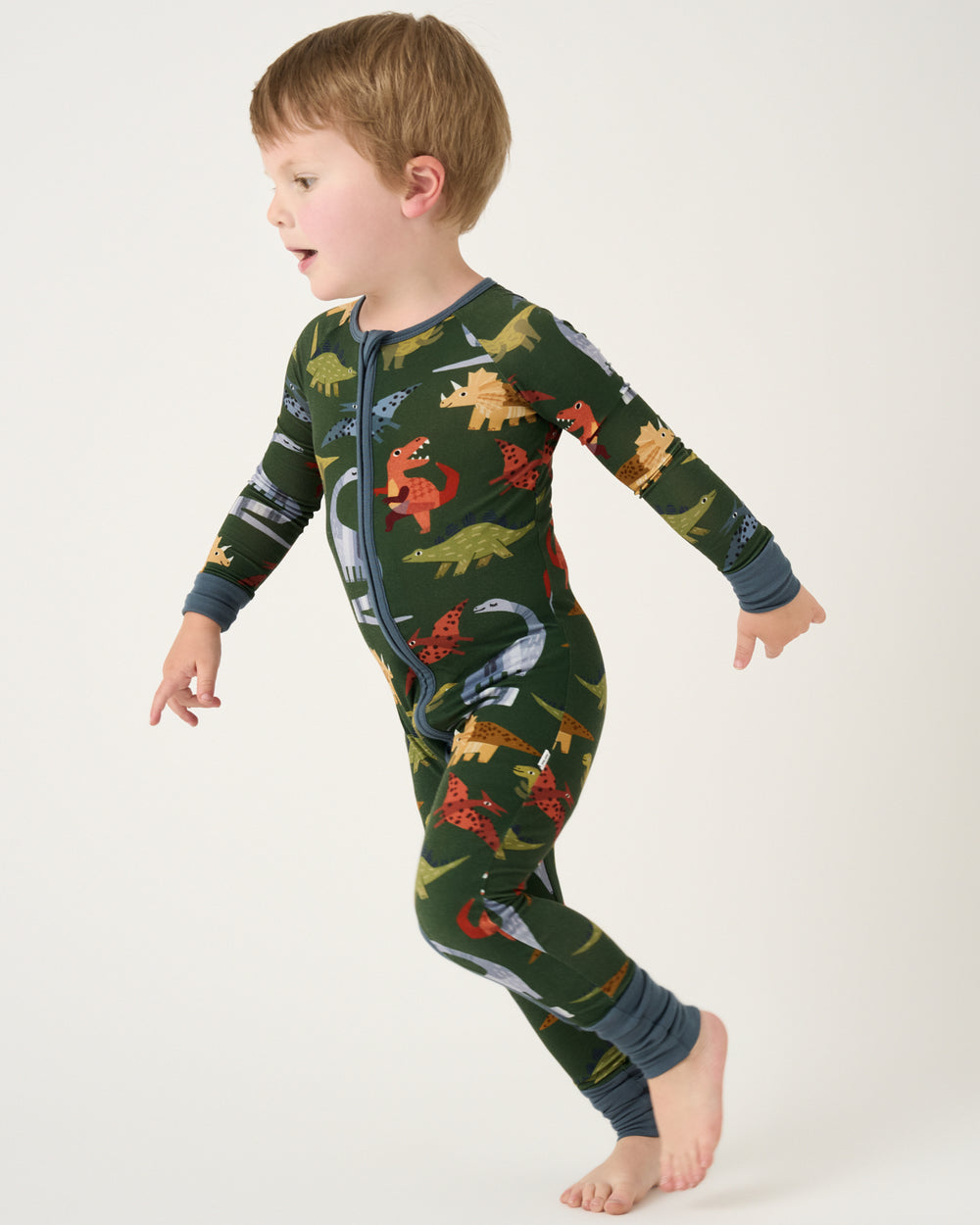 Running child wearing the Green Roar & Explore Zippy